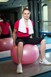 Pretty fit woman sitting on pink swiss ball