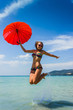 Foto: girl with orange umbrella on the beach in Thailand girl with orange umbrella on the beach in Thailand