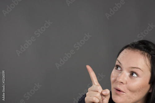 Photo: Frau zeigt auf etwas - Schild Frau zeigt auf etwas - Schild