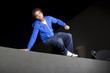 free runner doing parkour at night on a rooftop