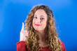 Photo: Beautiful Young Woman on Blue Background Beautiful Young Woman on Blue Background