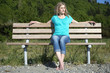 Young Woman Sitting On Bench At Beach