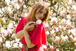 Junge Frau hält eine Magnolia Blüte in der Hand