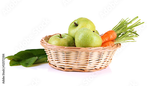 Photo: Juicy green apples and carrots with leaves in basket, isolated Juicy green apples and carrots with leaves in basket, isolated