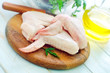 Raw chicken and knife on the wooden board