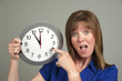 Woman with surprised expression holding a clock