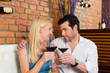 Foto: Attractive couple drinking red wine in restaurant or bar Attractive couple drinking red wine in restaurant or bar