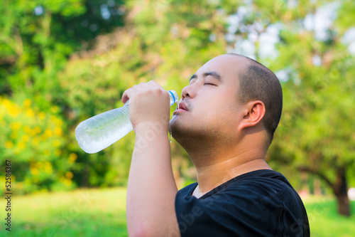 Photo: A bald head guy is pouring water into his mouth. A bald head guy is pouring water into his mouth.