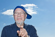 charismatic man in his 70s posing in front of blue sky