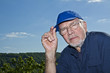 charismatic man in his 70s posing in front of blue sky