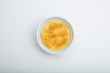 Creme brulee in ceramic bowl on white background