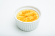 Creme brulee in ceramic bowl on white background