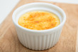 Creme brulee in ceramic bowl on cutting board