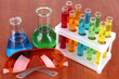 Test tubes with colorful liquids on wooden background