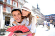Man giving piggyback ride to girlfriend in Madrid