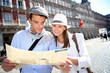 Couple of tourists looking at city map in Madrid