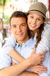 In love couple embracing each other in street
