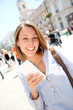 Photo: Cheerful girl using smartphone in town Cheerful girl using smartphone in town