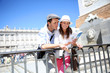 Couple reading traveler book by the Royal Palace of Madrid