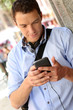 Man checking mails on smartphone in city street
