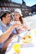 Cheerful couple of tourists eating churros in Madrid