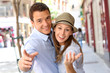 Cheerful couple pointing hand towards camera