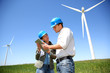 Engineers looking at wind turbine site with tablet