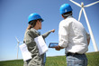 Engineers looking at wind turbine site with tablet
