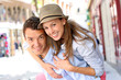 Man giving piggyback ride to girlfriend in town