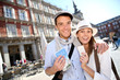 Cheerful couple showing visitor pass of Madrid