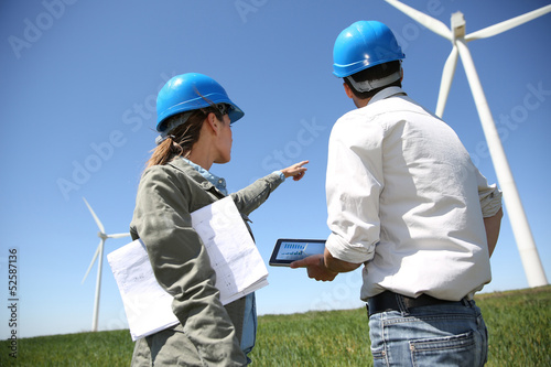 Photo: Engineers looking at wind turbine site with tablet Engineers looking at wind turbine site with tablet
