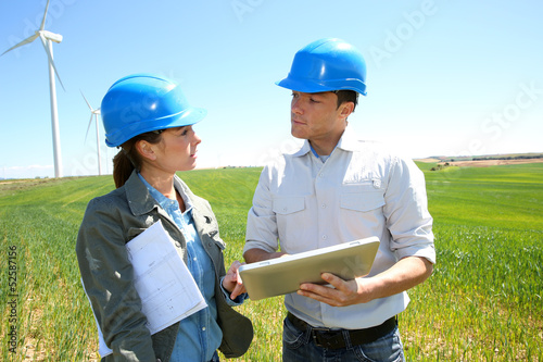 Photo: Engineers using tablet on wind turbine site Engineers using tablet on wind turbine site