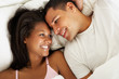 Couple Relaxing In Bed Wearing Pajamas