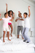 Family Jumping On Bed Together