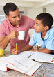 Father Helping Son With Homework In Kitchen