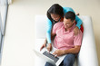 Overhead View Of Couple Relaxing On Sofa Using Laptop