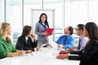 Businesswoman Conducting Meeting In Boardroom