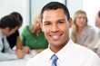 Portrait Of Businessman Sitting At Boardroom Table