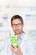 Foto: freundlicher apotheker mit einer packung tee freundlicher apotheker mit einer packung tee