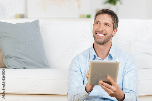 Photo: lachender mann mit tablet zu hause lachender mann mit tablet zu hause