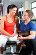 Trainer und Frau im Fitnessstudio