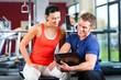 Trainer und Frau im Fitnessstudio