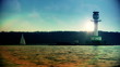 Lighthouse and sailboat at sunset
