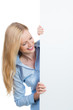 blonde junge frau schaut lachend auf schild