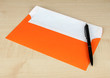 Envelope with pen on wooden background
