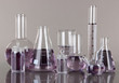 Test-tubes with light purple liquid on gray background
