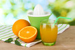 Citrus press, glass of juice and ripe oranges