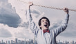 Businessman hanging on rope
