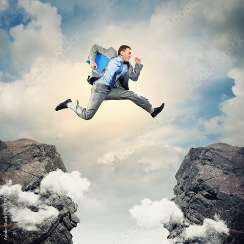 Photo: Businessman jumping over gap Businessman jumping over gap
