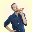 portrait of a young beautiful man eating a slice of pizza marghe